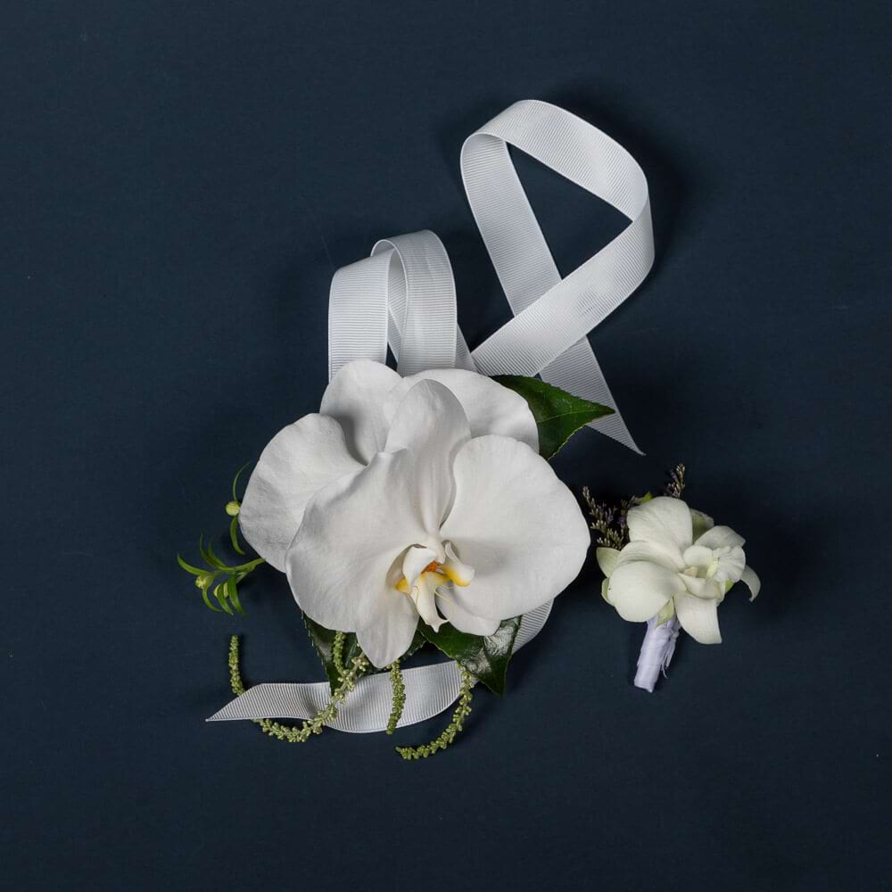 Matching white orchid school formal corsage and buttonhole set with complementary small flowers and ribbon