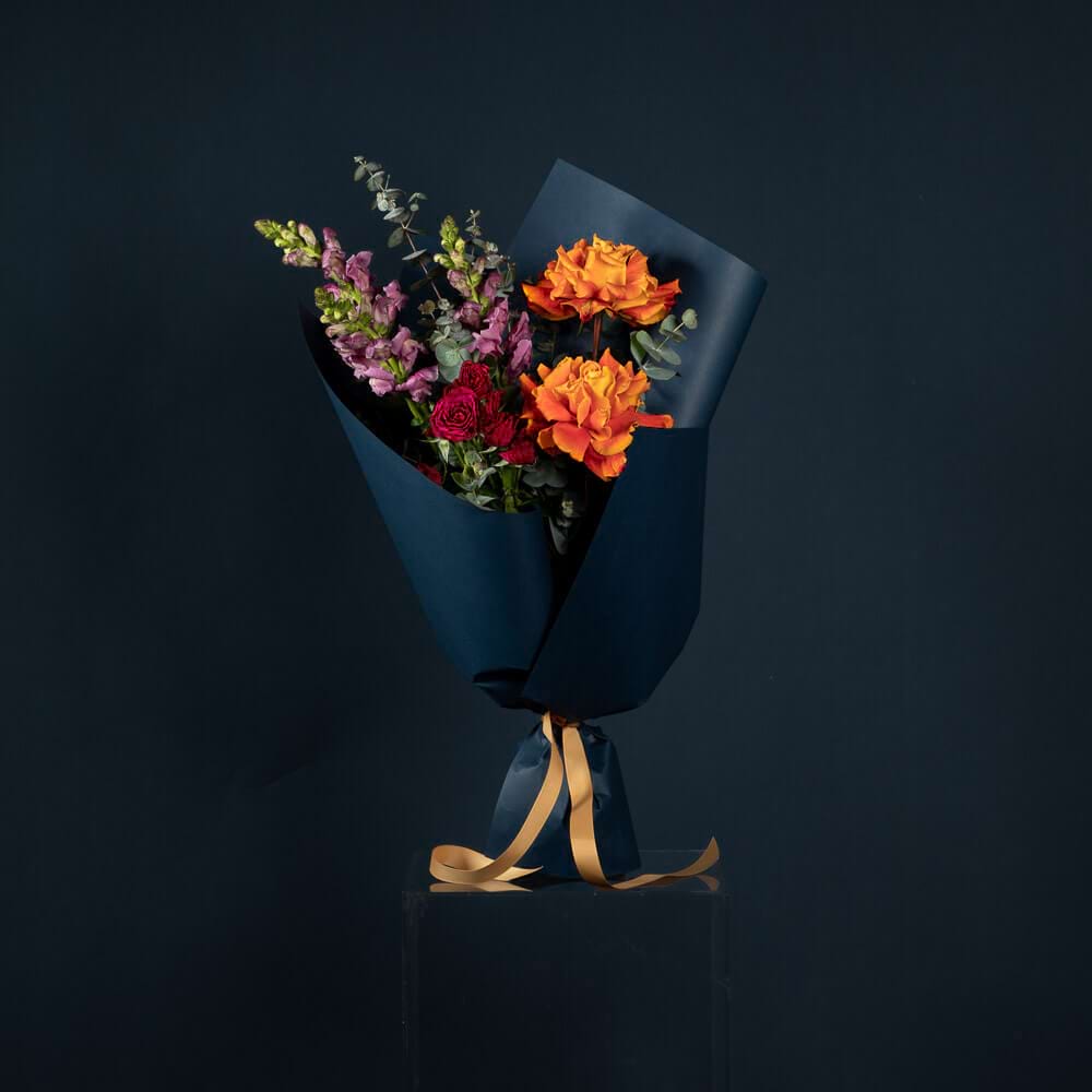 Bright Posy with orange roses, red flowers, purple snapdragons and eucalyptus foliage